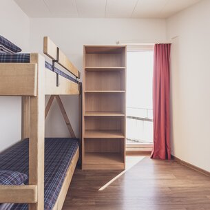 Zweibettzimmer mit Stockbett, Tisch, Stuhl und Fenster | © Davos Klosters Mountains 