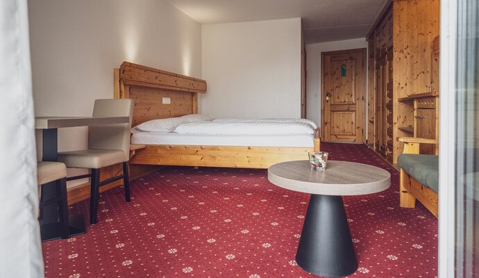 Doppelzimmer mit Teppich, Salontisch und Sitzgelegenheit  | © Davos Klosters Mountains 