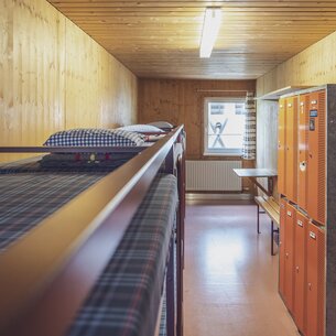 Zimmer mit mehreren Doppelstockbetten und Schliessfächern | © Davos Klosters Mountains 