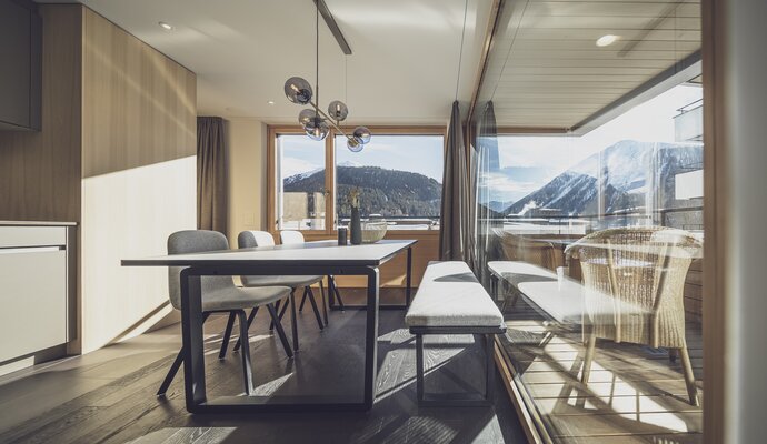 Grosser Esstisch mit grosser Glasfront und viel Aussicht auf die Berge | © Davos Klosters Mountains
