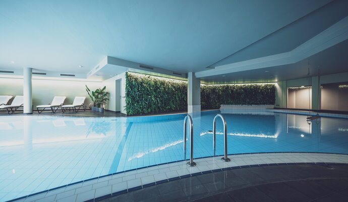 Indoorpool beleuchtet mit Ruheliegen | © Davos Klosters Mounains 